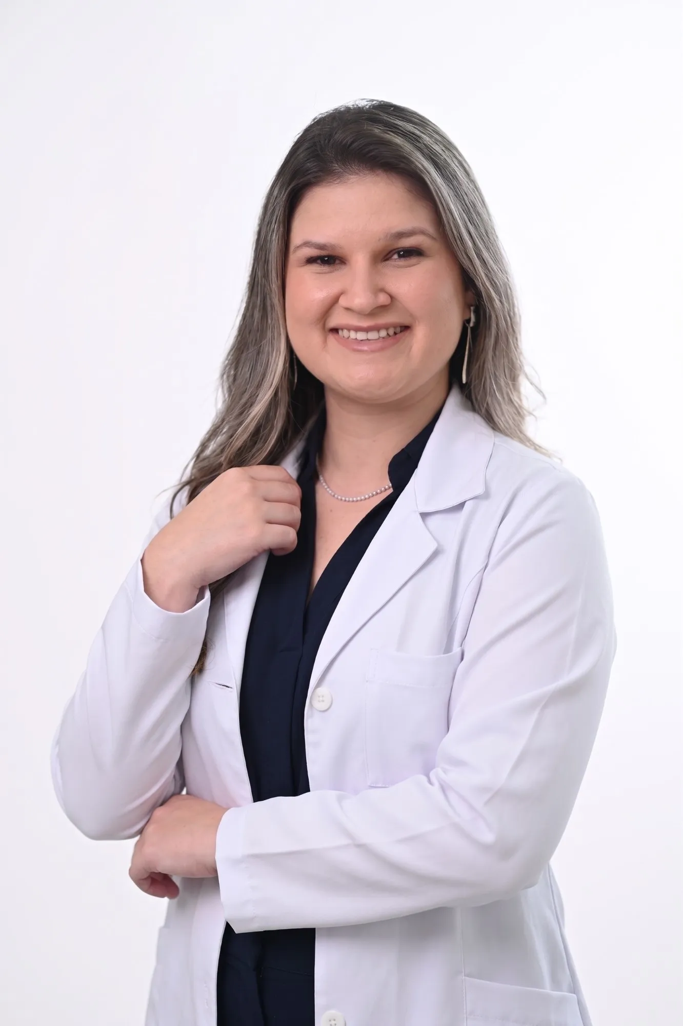 Eduarda Gnutzmann Mortais, fisioterapeuta, sorrindo, de jaleco branco
